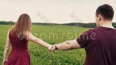 浪漫的年轻情侣牵着手，走在一片长草的田野里。 慢莫，稳定射击